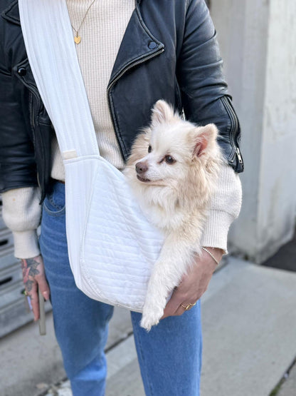 Cute small white dog being carried in our white, quilted, over the shoulder bag.