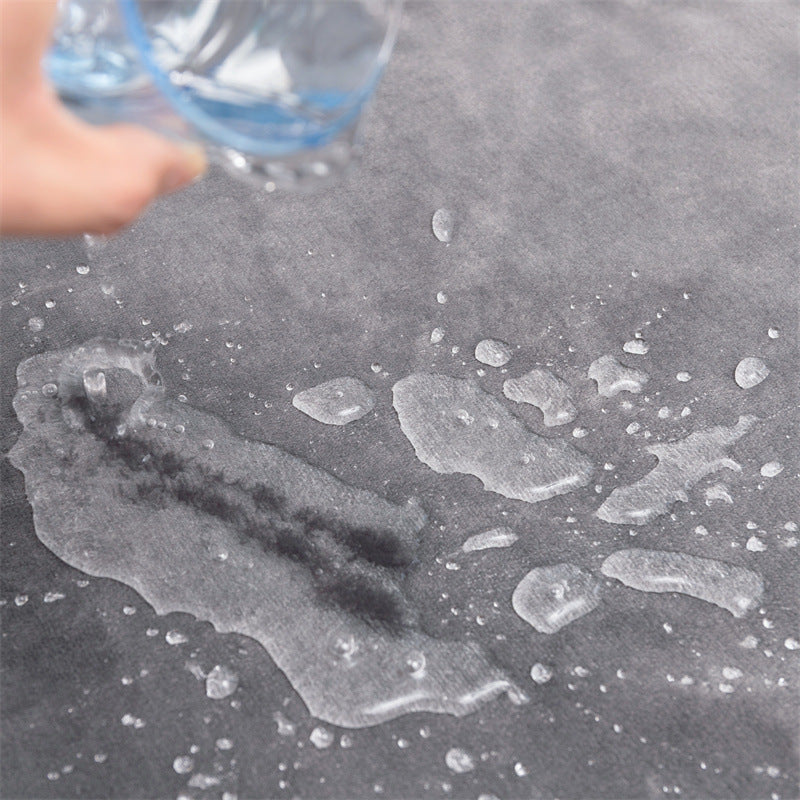 Slate colour dog blanket having water spilled on it to show it is waterproof